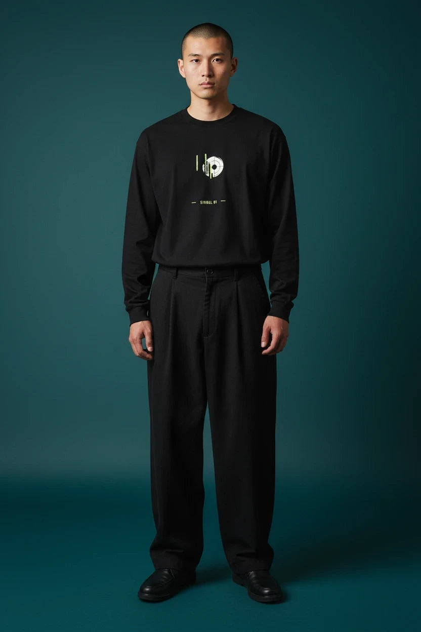 ODD COMMON black long-sleeve graphic t-shirt with lime green signal wave print worn by a man against a dark background