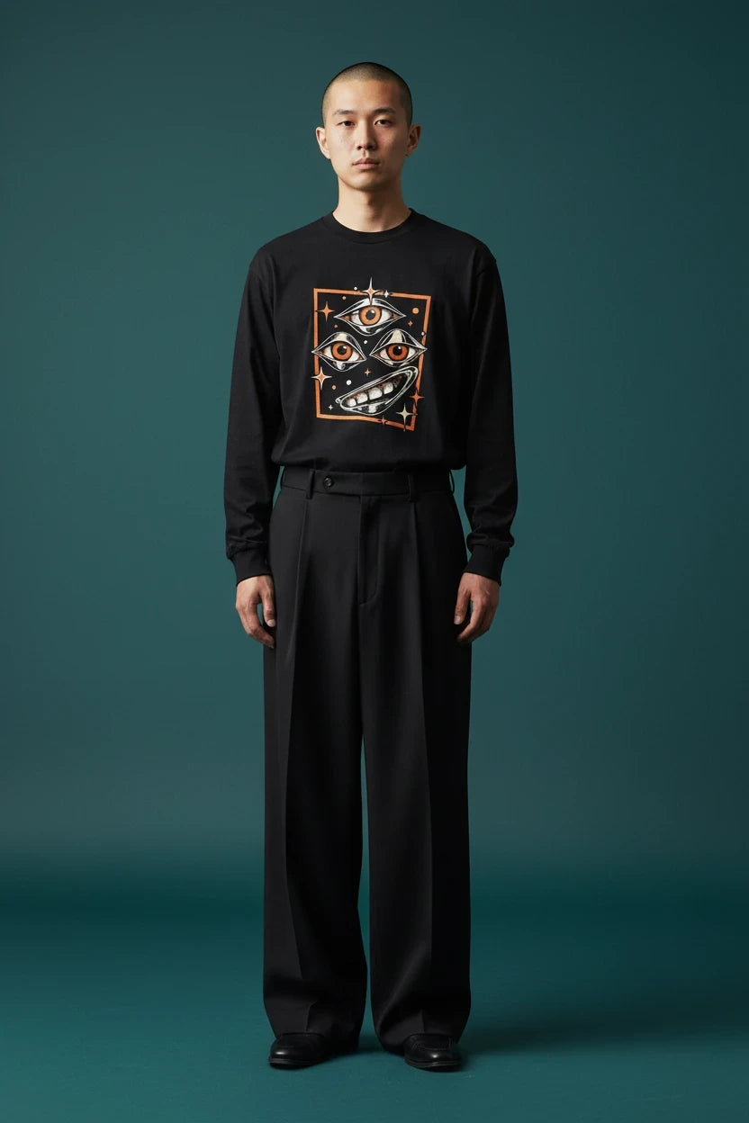 ODD COMMON black long-sleeve graphic t-shirt featuring a surreal three-eye illustration on a male model