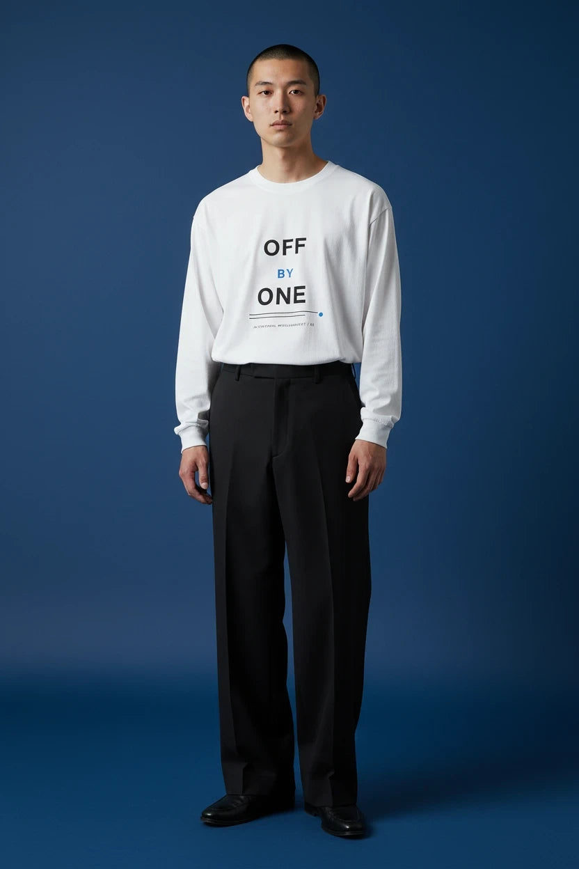 ODD COMMON white long-sleeve t-shirt with Off By One graphic text worn by a man against a blue background
